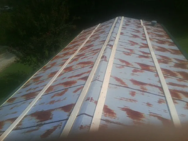 Rusted metal roof panels with new wood purlins before replacement — Storm Damage Roof Repair in Menlo by Roofing Brothers
