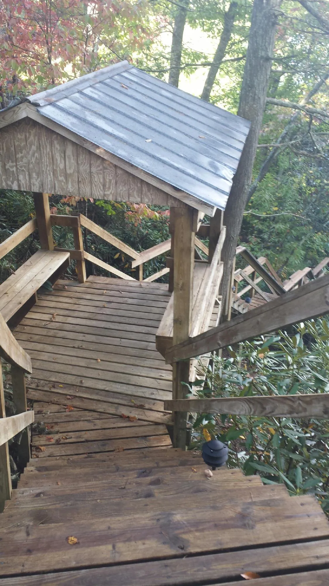 Metal roofed shelter over wooden steps on a wooded walkway — Skylight Repair & Installation work by our crew in Menlo